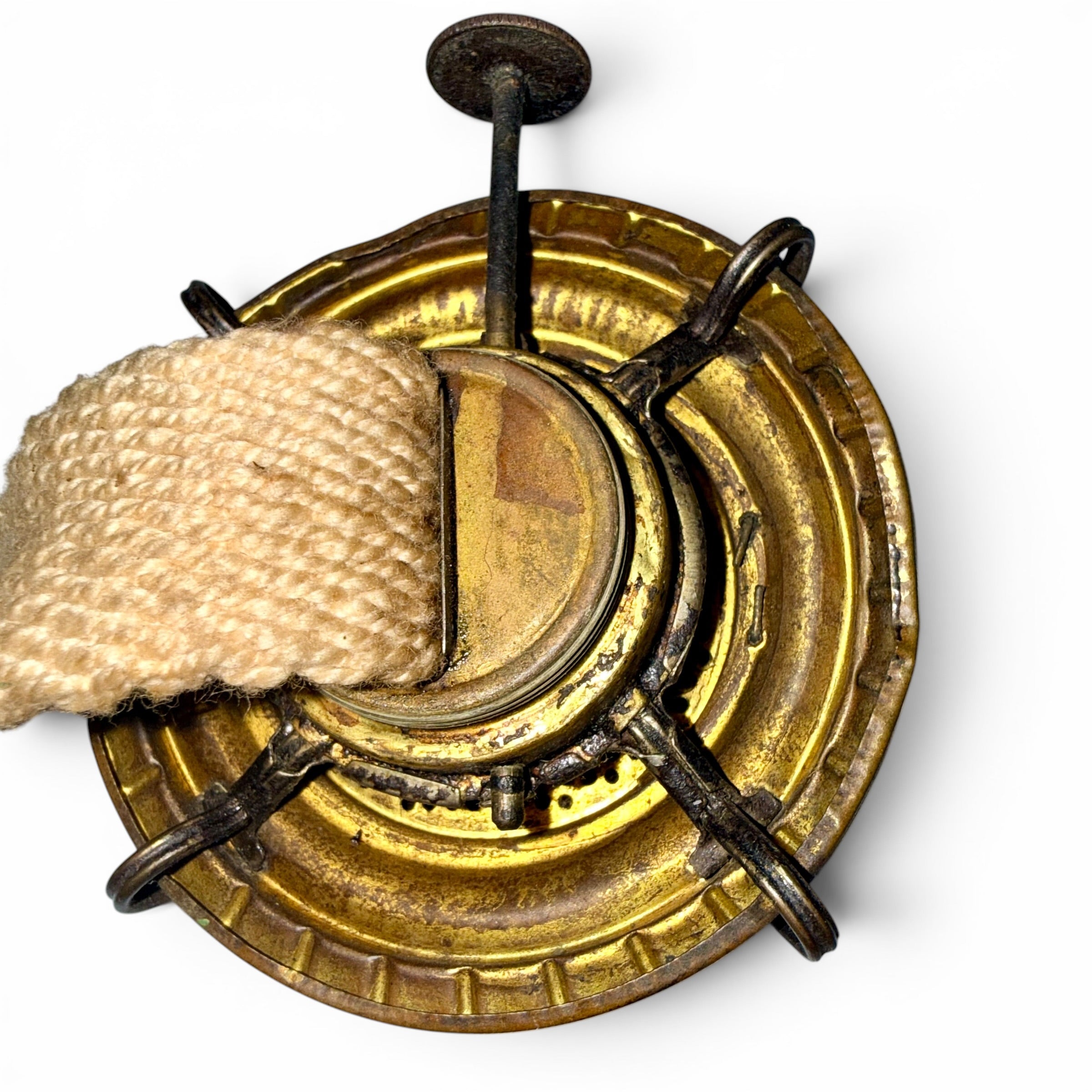 Close-up of a brass burner with cotton wick on a white background